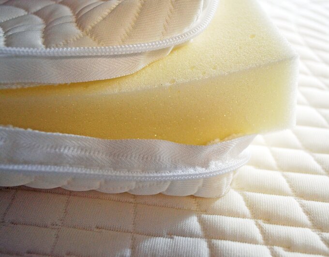 Close-up of a mattress cross-section with a foam core and quilted cover