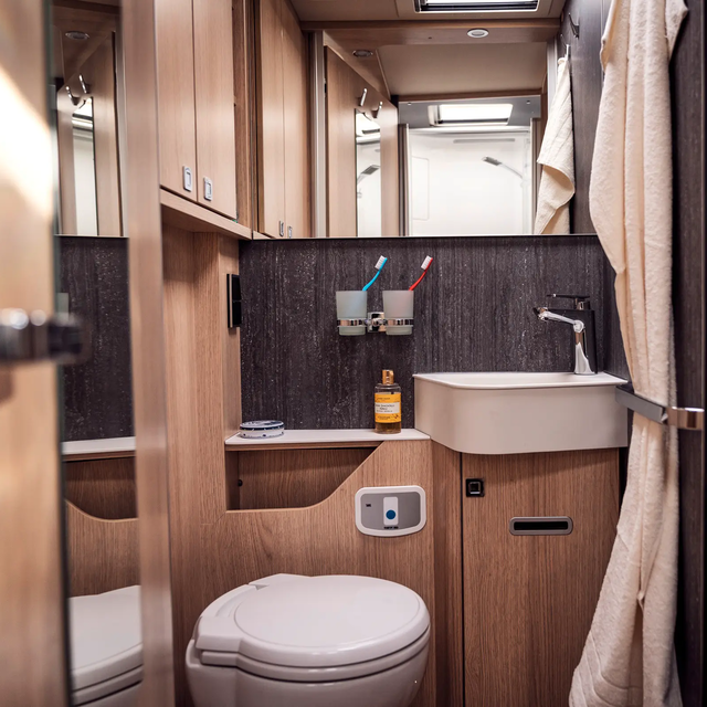 Daglicht badkamer met bergruimte, wastafel; Handdoekhouder, spiegel, kapstok en toilet in de HYMER B-ML T
