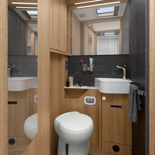 Daglicht badkamer met bergruimte, wastafel; Handdoekhouder, spiegel, kapstok en toilet in de HYMER B-ML T