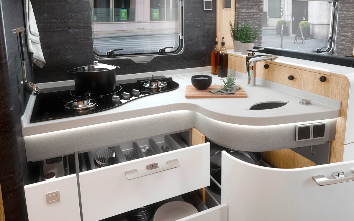 Keukenblok met open lades, kookplaat en werkblad in de HYMER MasterLine