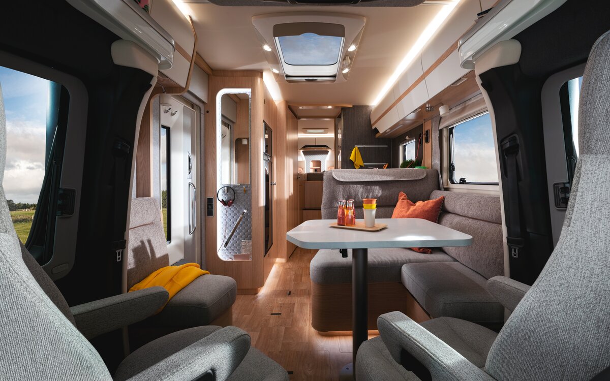 Zicht op het woongedeelte van de bestuurdersstoel naar het zitgedeelte naar het bed achterin in de HYMER B-klasse MasterLine T 780