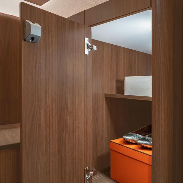 Open kledingkast met planken, gevuld met een oranje doos en zilverkleurige ballerina's in de HYMER B-ML T