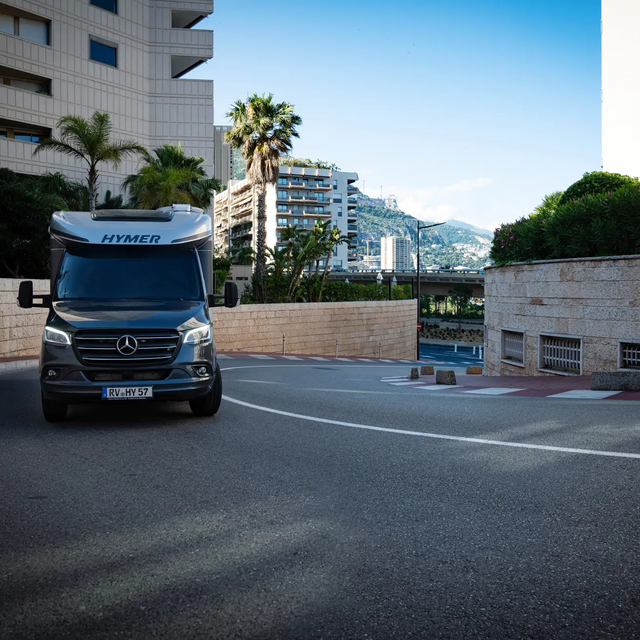 Kloof van huizen in een mediterrane kustplaats met een HYMER B-ML T die in een bocht van de straat be