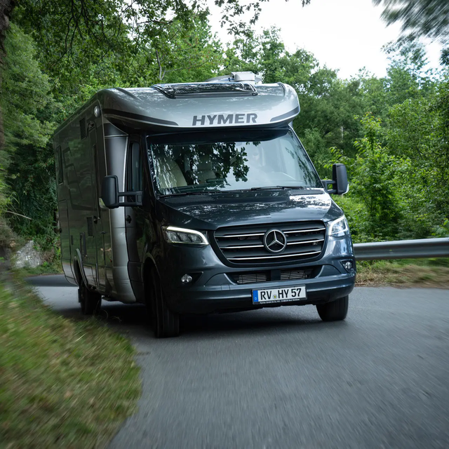 HYMER MasterLine T op Mercedes-chassis bergopwaarts door een beboste weg rondom