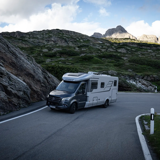 HYMER B-MasterLine T bergopwaarts rijdend op een kronkelige weg met rotsen in de berm