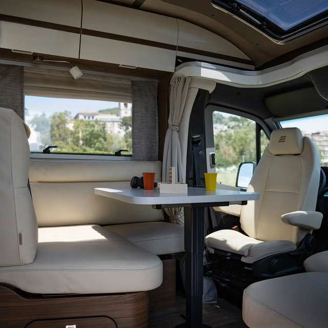Crèmekleurige comfortabele L-zitgroep in lederlook inclusief bestuurdersstoelen en gedekte tafel in de HYMER B-MasterLine