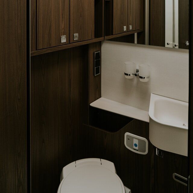 Cabinet de toilette en décor bois sombre dans un camping-car