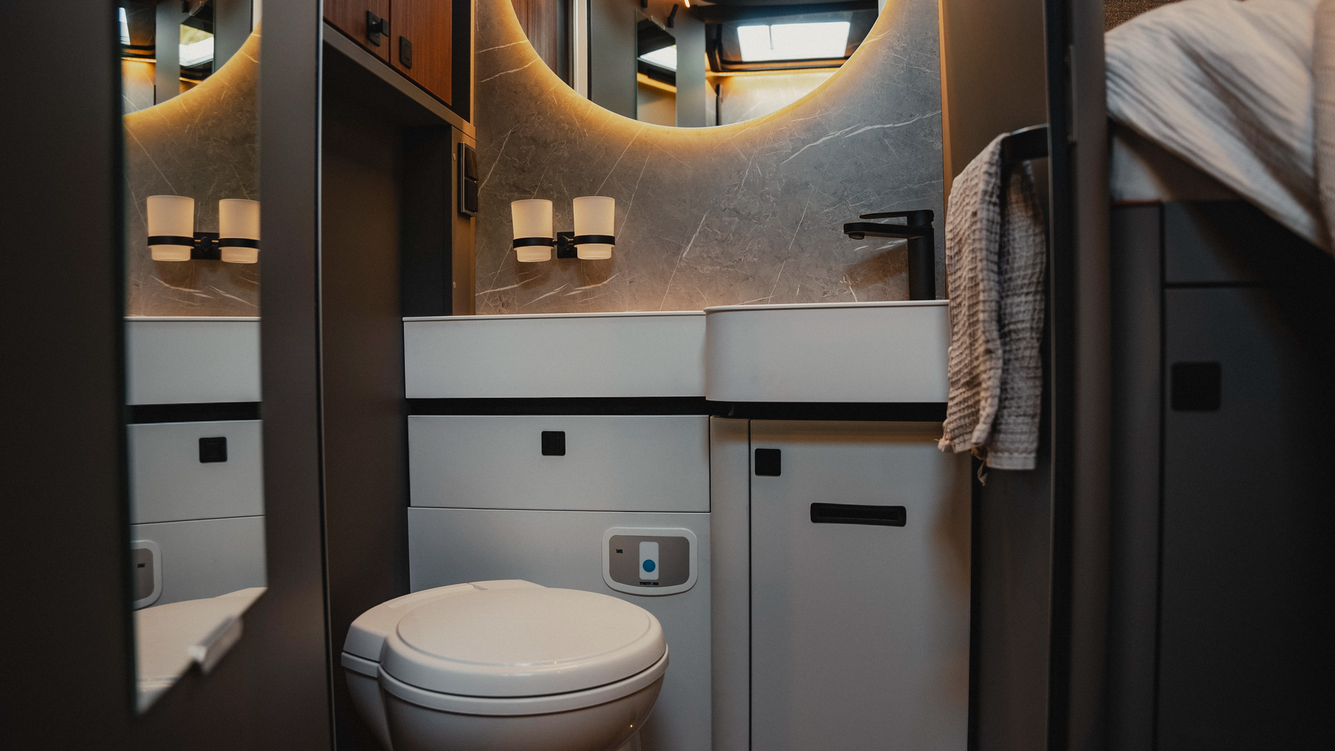 The stylish bathroom offers a modern wash area, characterised by smart design and modern equipment. Experience functionality and elegance in a room that is perfectly tailored for travel and creates an inviting atmosphere.