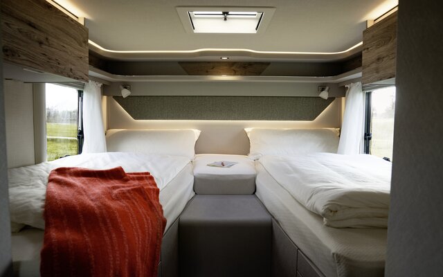 Covered lengthways single beds and red blanket in the rear of the HYMER Exsis 580 Pure
