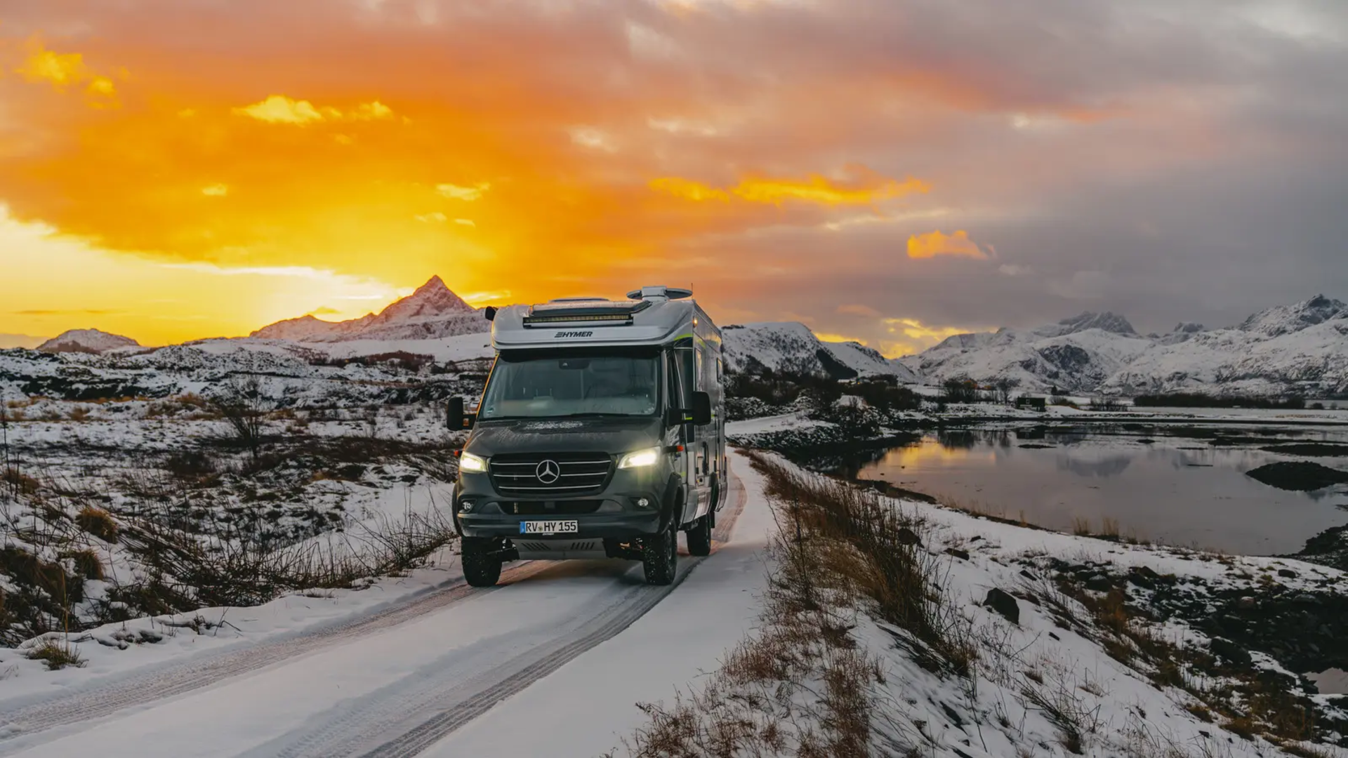 HYMER ML-T 570 driving on the road, snowy mountains and a beautiful sunset in the background